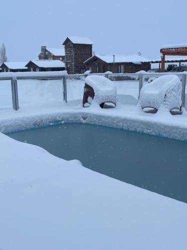 un patio cubierto de nieve con coches cubiertos de nieve en Naol village en Uspallata