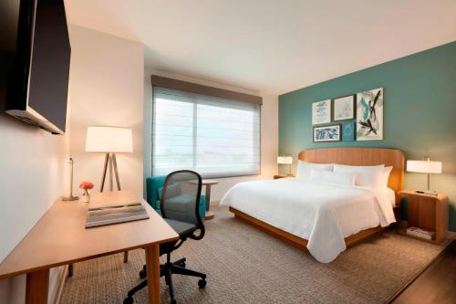a hotel room with a bed and a desk and a computer at Element Dallas Love Field in Dallas