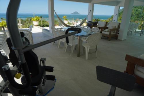 a room with a table and chairs and the ocean at Suites em Juquei in Juquei