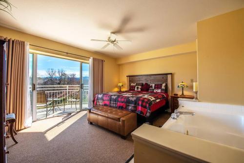 Schlafzimmer mit einem Bett und einer Badewanne sowie einem Balkon in der Unterkunft Amazing Mountain Views, 5 min to Dollywood&parkway in Pigeon Forge