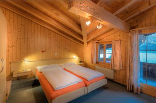 a bedroom with a bed in a room with a window at Hotel Wildbach Brienz in Brienz