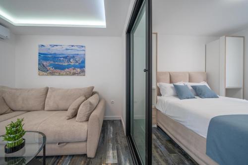 een slaapkamer met een bed en een bank bij Zoi apartment in Kotor
