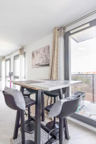 une table et des chaises dans une pièce avec une fenêtre dans l'établissement Cocon Villanueva, à Saint-Denis