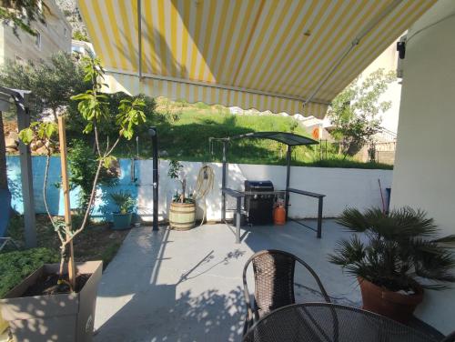 un patio con 2 sillas y una mesa con plantas en Apartments Milina, en Omiš