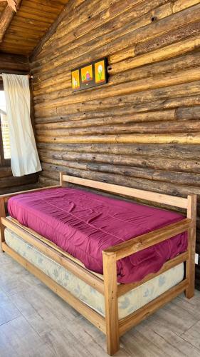 a wooden cabin with a bed in a room at Naol village in Uspallata