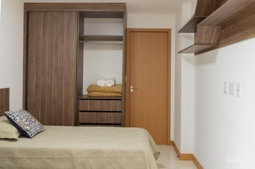 a bedroom with a bed and a closet with towels at Kalug - BEIRA À MAR, wi-fi 200mbps, ACADEMIA, espaço kids e GARAGEM na Praia dos Milionários in Ilhéus
