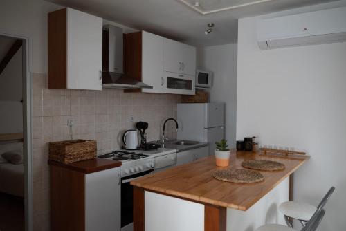 Apartman Milutin في فرسي: مطبخ بأدوات بيضاء وقمة خشبية