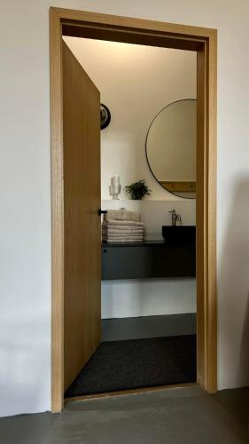 a door leading into a bathroom with a mirror at Smiðjan - main road Stykkishólmi in Stykkishólmur