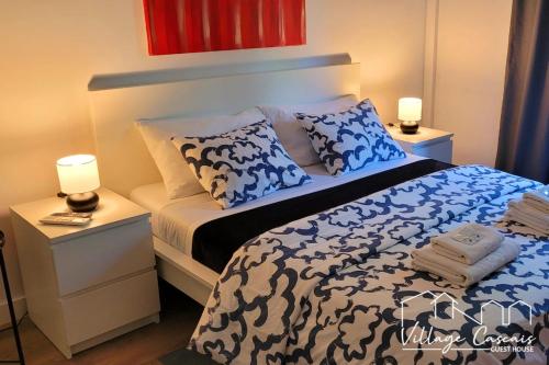 a bedroom with a blue and white bed and two lamps at Village Cascais Guest House in Cascais