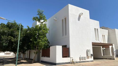 ein weißes Gebäude an der Straßenseite in der Unterkunft فيلا رضوى الخير in Madīnat Yanbu‘ aş Şinā‘īyah