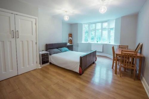 a bedroom with a bed and a table and a desk at 4 Bedroom in Finchley Road in London