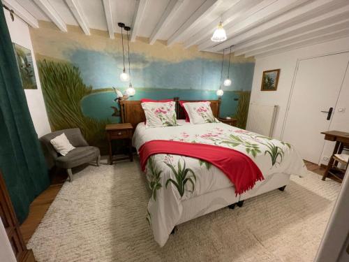 1 dormitorio con 1 cama y una pintura en la pared en La demeure de Liers, en Sainte-Geneviève-des-Bois