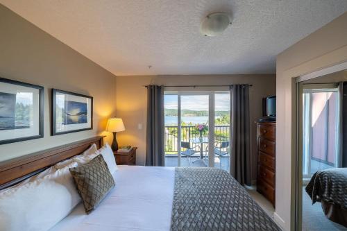 a bedroom with a bed and a balcony at Sooke Harbour Resort & Marina in Sooke