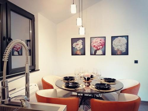een eetkamer met een tafel en oranje stoelen bij Vineyard Apartment in Ohrid