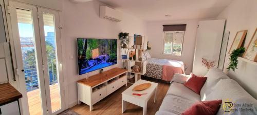 sala de estar con sofá y TV grande en VIVIENDA TURISTICA PLAYA ALTAIR PUNTA UMBRIA, en Punta Umbría