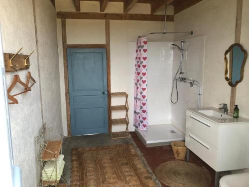 ein Badezimmer mit einer blauen Tür und einem Waschbecken in der Unterkunft Le Tarde - Crécerelle in Saint-Désiré