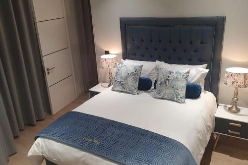 a bedroom with a large bed with two lamps at Ellipse Waterfall - The Loft at Cassini in Midrand