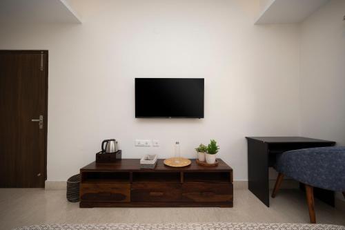 a living room with a tv on a white wall at Lakeside Suites in Kolkata