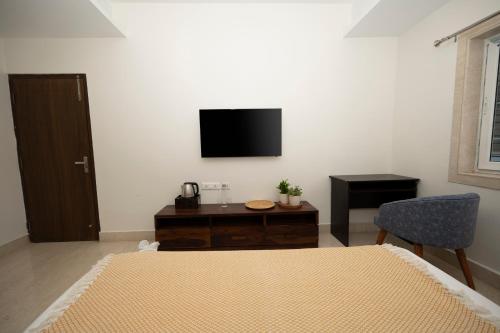 a bedroom with a bed and a tv on the wall at Lakeside Suites in Kolkata