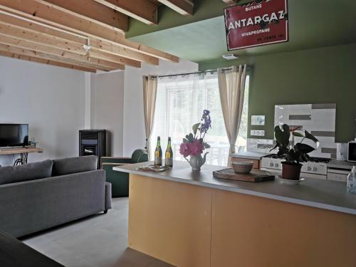 una cocina y una sala de estar con una barra con flores. en Les gîtes de L'hermine, en Plouigneau