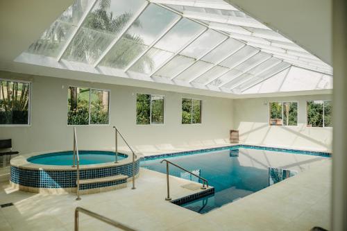 an indoor swimming pool with a glass ceiling at Paraty Hotel Fazenda & Spa in Ibiúna