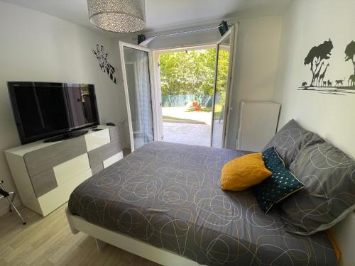 1 dormitorio con 1 cama y TV de pantalla plana en Welcome to Hakuna matata ! en Chanteloup-en-Brie