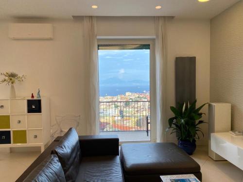 ein Wohnzimmer mit einem Sofa und einem großen Fenster in der Unterkunft Oliver Luxury Home in Neapel