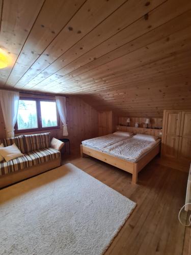 1 dormitorio con 1 cama y 1 sofá en una cabaña en Burtscha Lodge im Sommer inklusive der Gästekarte Premium en Bürserberg