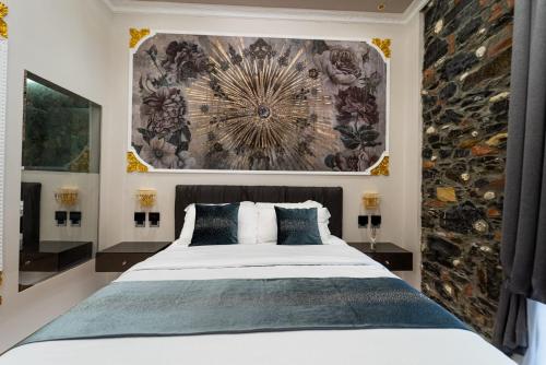 1 dormitorio con 1 cama y una gran pintura en la pared en Queen Cattleya Suite en Génova
