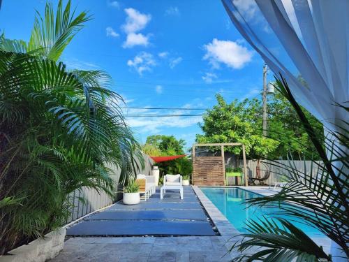 a swimming pool with a table and chairs next to a house at DreamHouse with Heated Pool in Fort Lauderdale