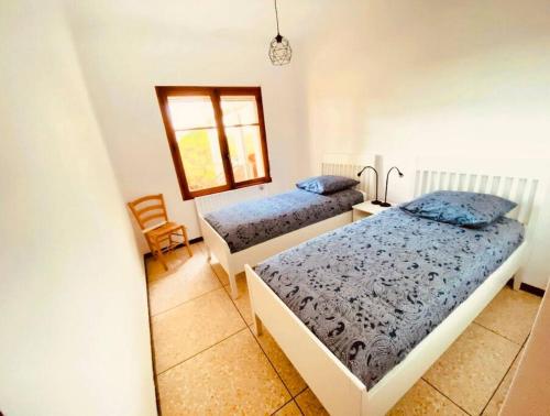 a bedroom with two beds and a window at Villa l’oliveraie in Sanary-sur-Mer