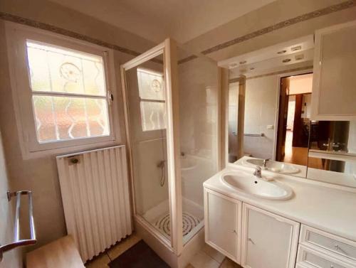 ein weißes Bad mit einem Waschbecken und einer Dusche in der Unterkunft Villa l’oliveraie in Sanary-sur-Mer
