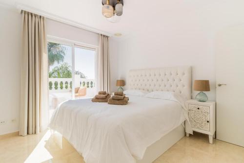 - une chambre blanche dotée d'un grand lit avec deux animaux rembourrés dans l'établissement ARCADIA - AVENIDA 28 De LAS ADELFAS 29680 ESTEPONA, MALAGA, à Estepona
