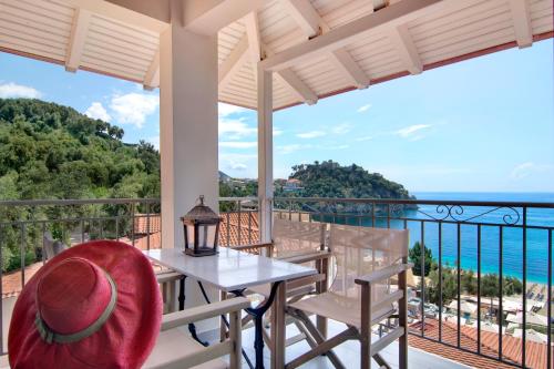 a balcony with a table and chairs and a view of the ocean at Valtos Beach Hotel in Parga