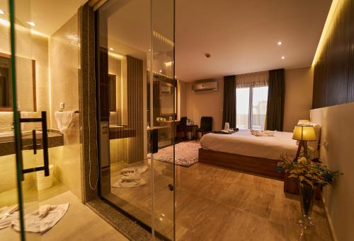 um quarto de hotel com uma cama e uma porta de vidro em New Pyramid Front Hotel em Cairo