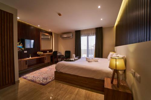 ein Hotelzimmer mit einem großen Bett und einem TV in der Unterkunft New Pyramid Front Hotel in Kairo