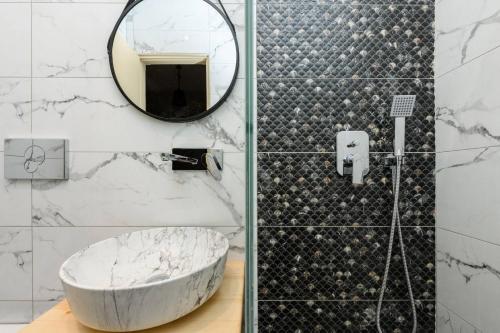 可因尼拉的住宿－Dimitreli Eleni Studios，一间带大型大理石浴缸和镜子的浴室