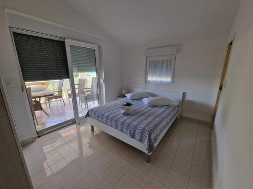 1 Schlafzimmer mit einem Bett und einem Balkon mit einem Tisch in der Unterkunft Apartman Lugović in Šibenik