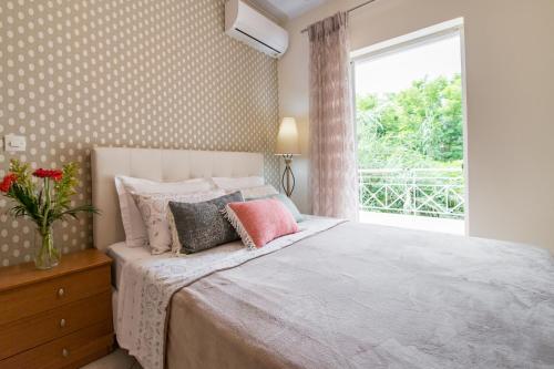 a bedroom with a bed with a vase of flowers on it at Charming Appt in Preveza