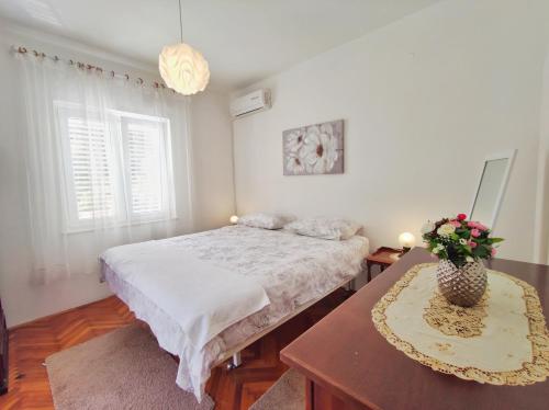 een slaapkamer met een bed en een tafel met bloemen erop bij Villa Kipre 2 in Cavtat