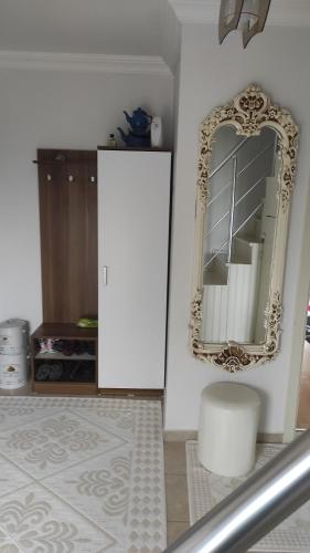 een spiegel aan een muur in een kamer met een kruk bij Aydınlar villa in Bostancı