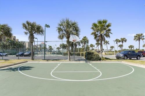 a basketball court in a parking lot with palm trees at Phoenix 5 Unit 1504 in Orange Beach