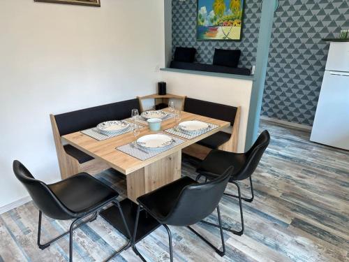 a wooden table with black chairs around it at Les hirondelles au bord de l'eau in Guipry-Messac