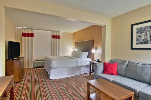 a hotel room with a bed and a couch at Four Points by Sheraton Nashville Airport in Nashville