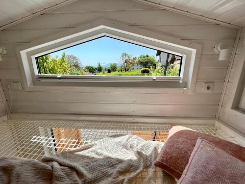 a bedroom with a window in a tiny house at Tiny House Gänseblümchen in Kirchanschöring