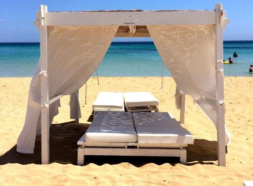 two beds on a beach with the ocean in the background at Villa Floyd Charming Rooms B&B in Pachino