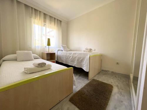 Cette petite chambre comprend 2 lits et une fenêtre. dans l'établissement Precioso Apartamento Puerto Banus Marbella, à Marbella