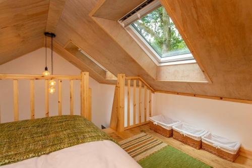 a attic bedroom with a bed and a window at The Dairy in Tavistock