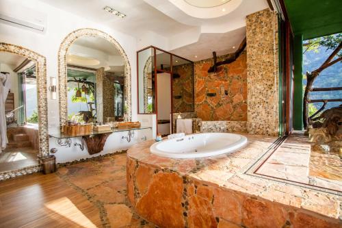 a large bathroom with a large tub and a large mirror at Villa Lala Boutique Hotel Adults Only in Puerto Vallarta