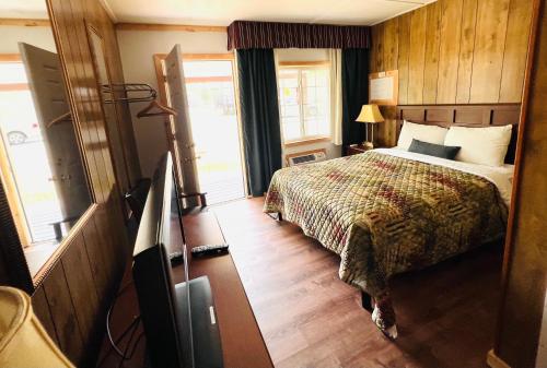 1 dormitorio con 1 cama y TV. en Countryside Inn Lake George, en Lake George